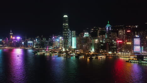 hong kong night aerial view of hong kong island, boats sailing on victoria harbour