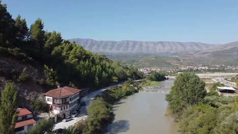 traditional albanian house next to a river in a mountainous area