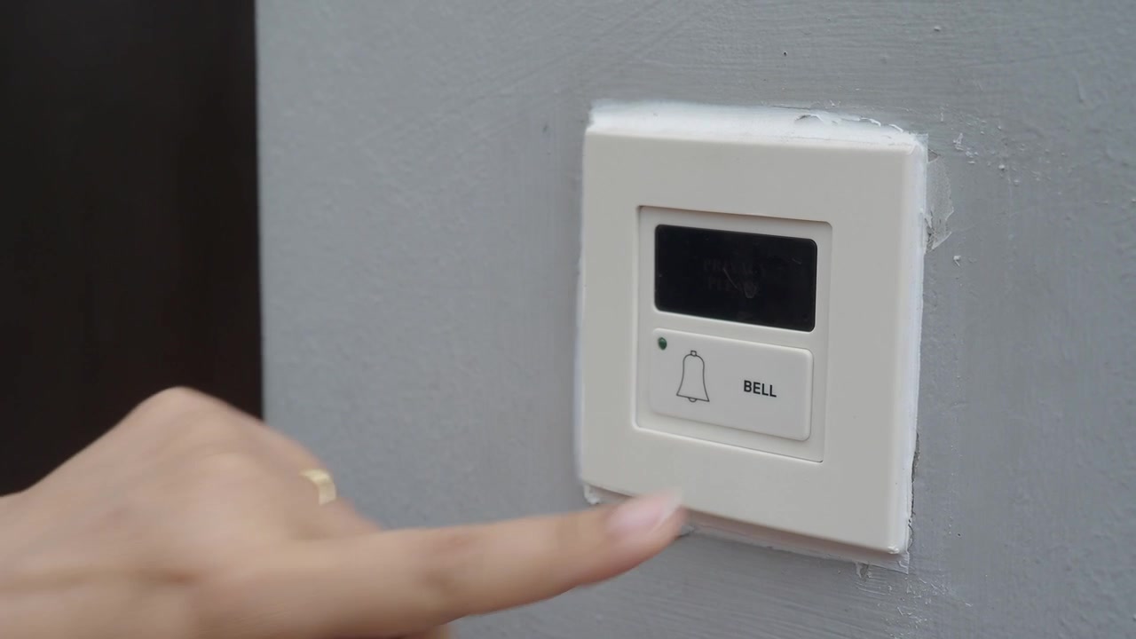 Person Pressing a Modern Doorbell Button