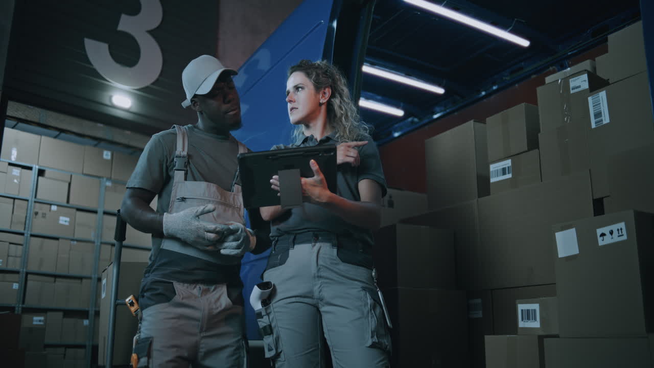 Female warehouse manager uses digital tablet at loading dock for inventory