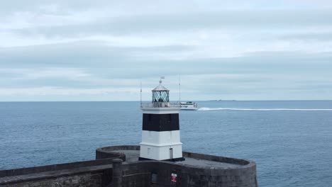 Holyhead-breakwater-lighthouse-longest-concrete-coastal-sea-protection-landmark-aerial-view-ferry-cruising-horizon