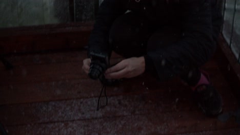 Woman-taking-a-picture-of-a-baby-gray-wolf-during-a-snowstorm