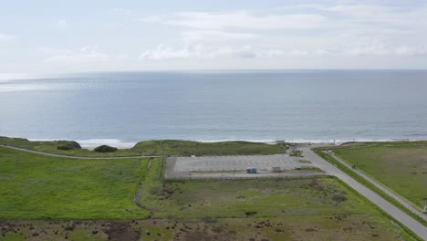 aerial: parking lot and ocean view in half moob bay beach, panning right