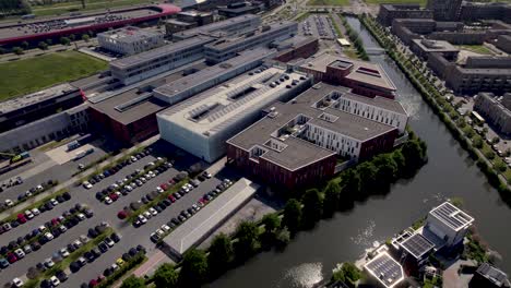 Aerial-rotating-pan-showing-Dutch-Antonius-hospital-surrounded-by-water-in-city-of-Utrecht-with-'The-Wall'-shopping-in-the-background-in-contemporary-Leidsche-Rijn-neighbourhood