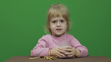 The-child-eats-cookies.-A-little-girl-is-eating-cookies-sitting-on-the-table.