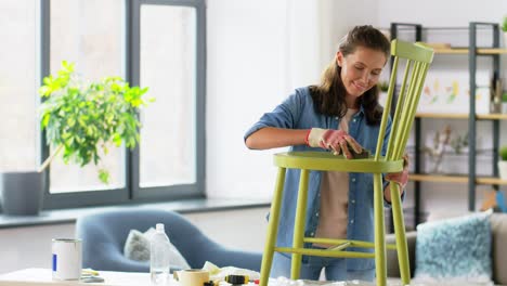 furniture-renovation,-diy-and-home-improvement-concept--happy-smiling-mother-and-daughter-sanding-old-round-wooden-chair-with-sponge-at-home