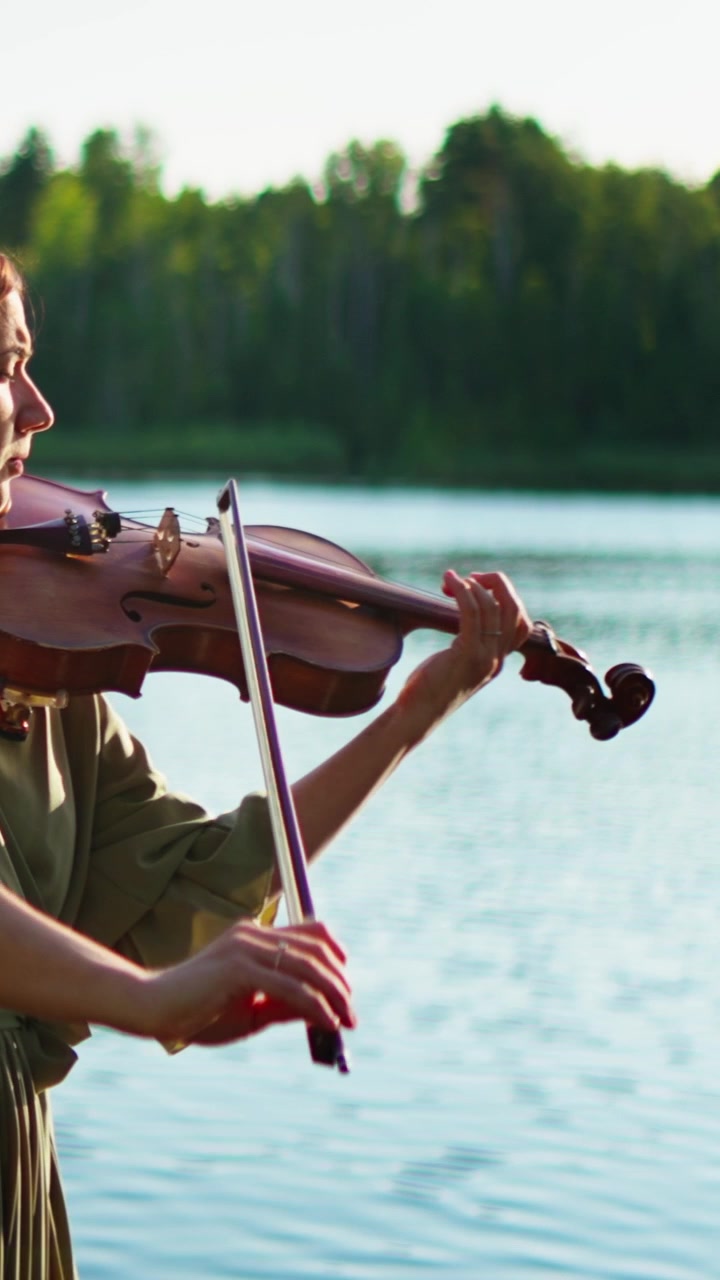 Woman Playing Violin by a Serene Lake at Sunset
