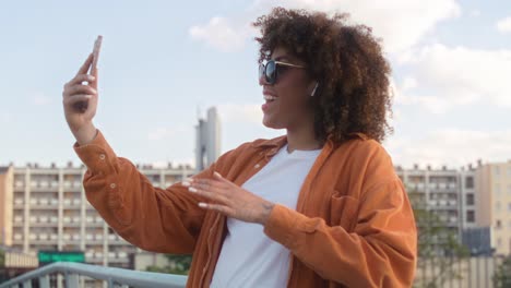 Black-woman-standing-on-the-bridge-and-having-a-video-call