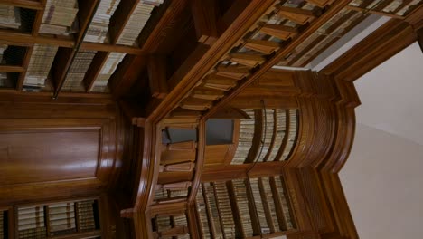 vertical - antique wooden bookshelves with old volumes of books in biblioteca teresiana in mantua, italy