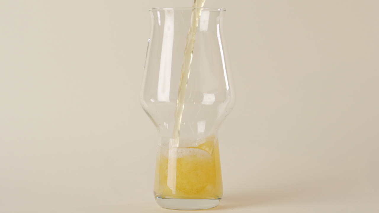 흰색 배경에서 100fps로 맥주 시음 잔에 차가운 곰을 붓는다