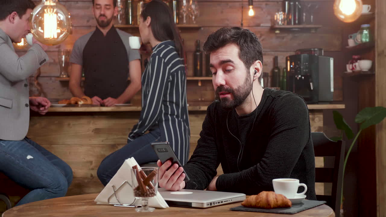 People in a cafe with laptops and phones