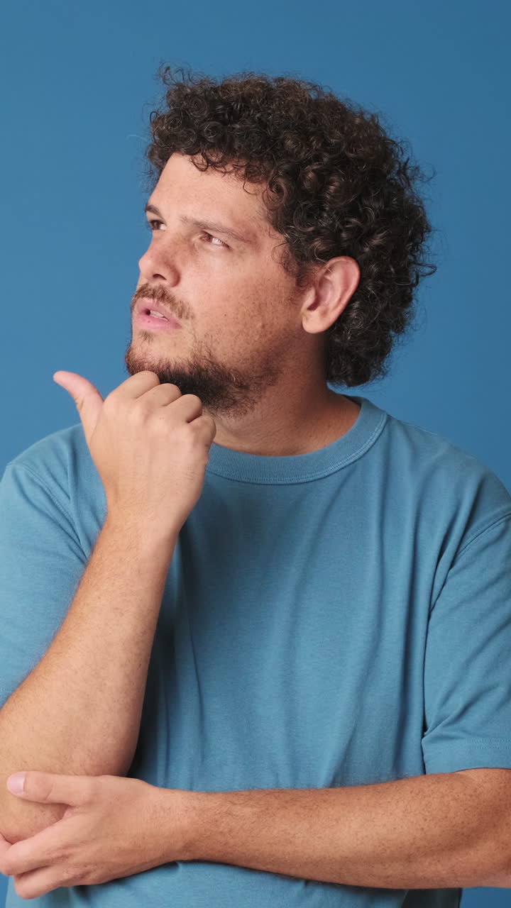 Uomo che pensa e indica, poi sorride con sicurezza