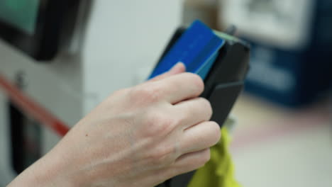 close view of a person making a payment with a card. the video is shot from a first-person perspective with a handheld camera, showing a hand inserting a credit card into a payment terminal