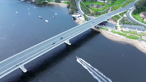 tráfico de automóviles aéreos no tripulados que pasan por la autopista con barco en la infraestructura de transporte fluvial clyde river batemans bay costa sur de australia