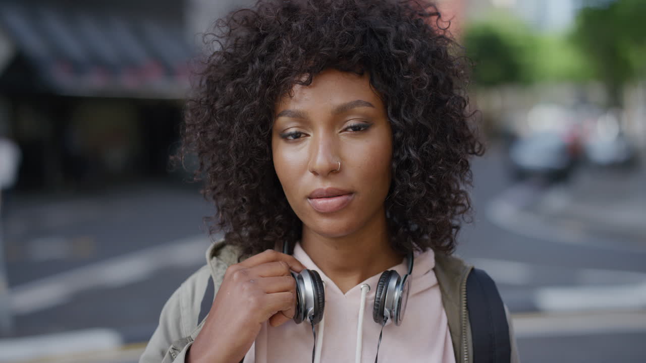 retrato de una hermosa mujer afroamericana mirando tranquila y pensativa a la cámara estudiante negra en la ciudad urbana fondo serie de personas reales