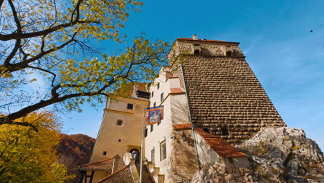 exterior of bran castle with brick wall. low angle vie on the entrance into building. autumn sunny day outdoor.