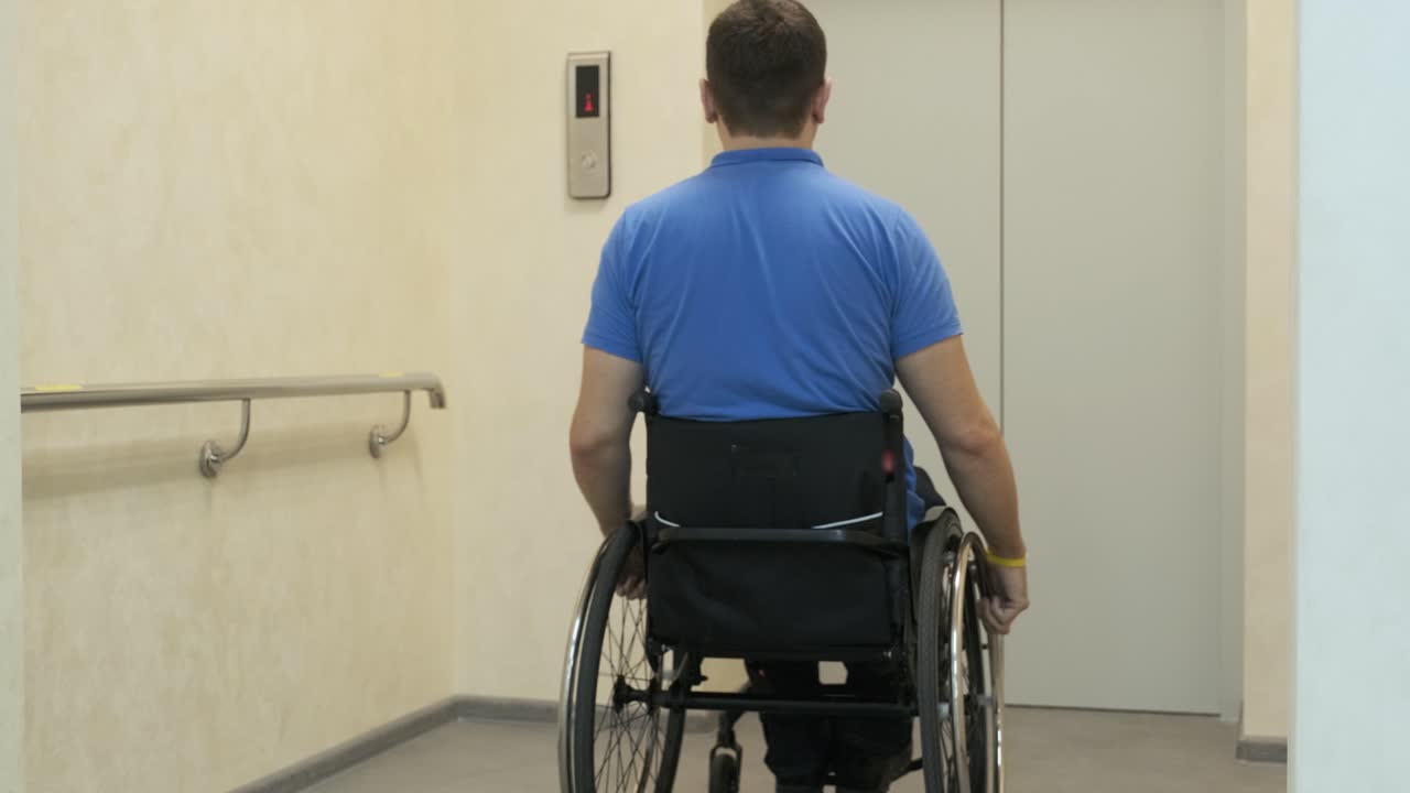 un hombre en silla de ruedas entra en el ascensor. una persona con discapacidad viaja en un ascensor.