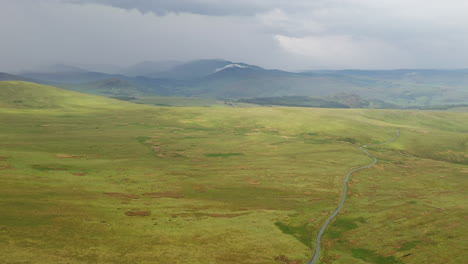 aerial view of a single mountain road, winding through the countryside, in the the english lake district