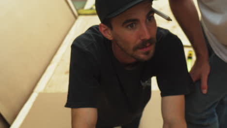 closeup of caucasian skateboarder with hat discussing how to build skateboard ramp in backyard