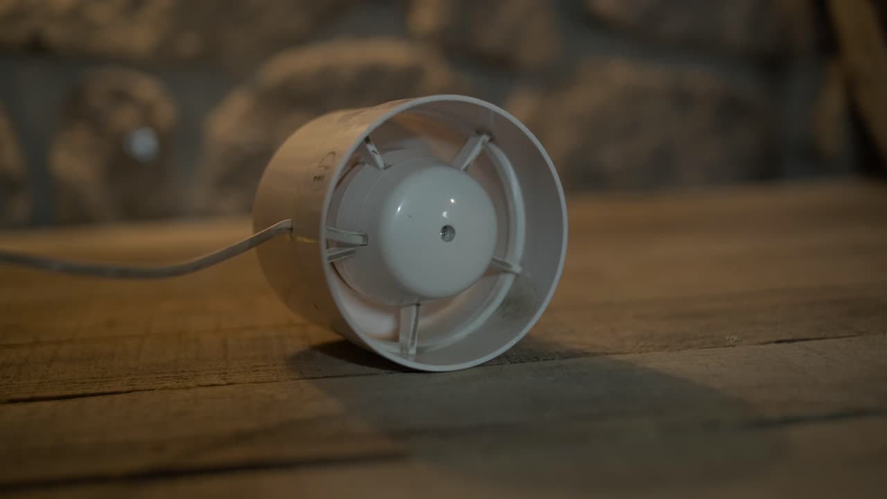 White Exhaust Fan Spinning on a Wooden Surface
