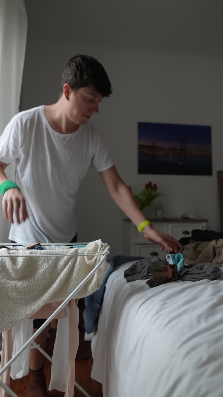 Man Doing Laundry in a Bedroom