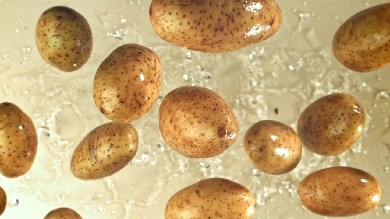 Patate fresche che schizzano nell'acqua al rallentatore