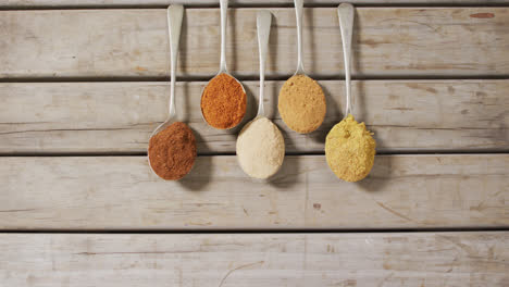 video of spoons with diverse seasonings lying on wooden surface