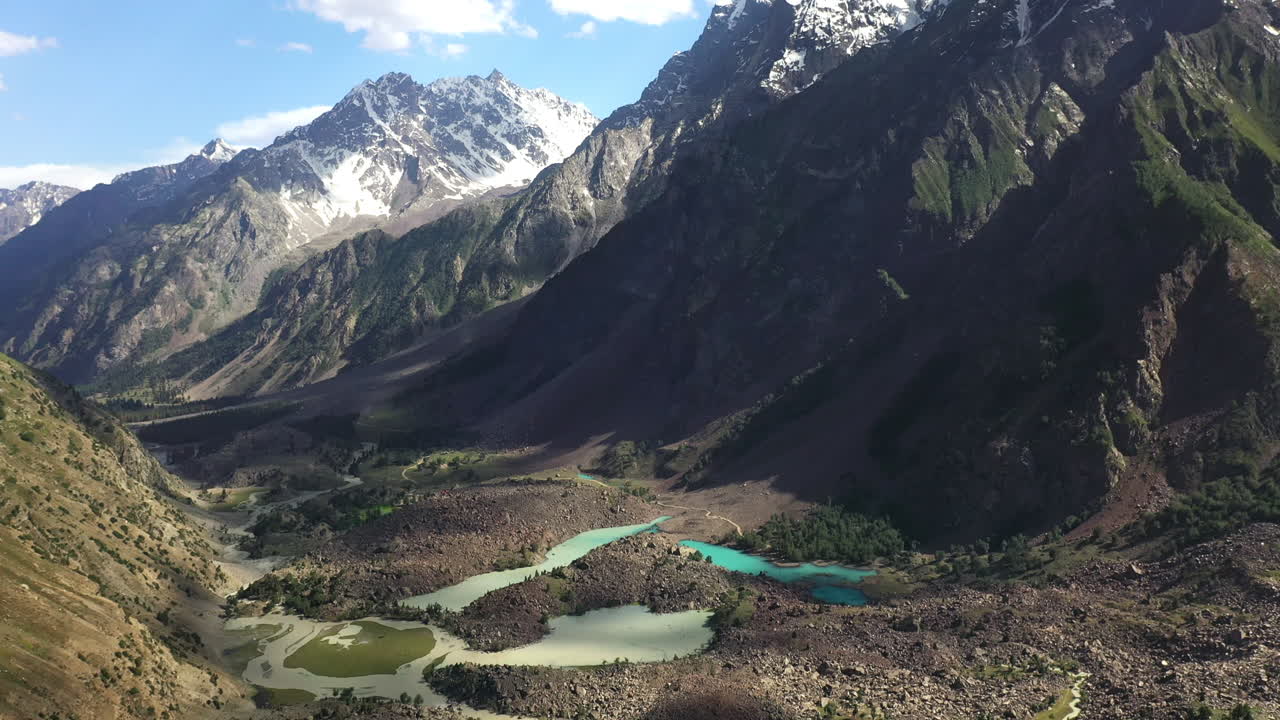 toma cinematográfica de drones del agua de color turquesa en las montañas en el valle de naltar en pakistán, revelando la toma aérea del paisaje montañoso