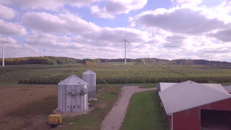 imágenes aéreas volando sobre tierras de cultivo con graneros rojos y silos de acero con transportadores