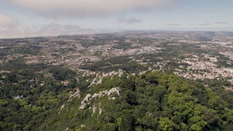 Punto-De-Referencia-Turístico-De-La-Unesco,-Castillo-De-Los-Moros-En-La-Colina-En-Sintra-Portugal,-Tiro-Panorámico-Aéreo