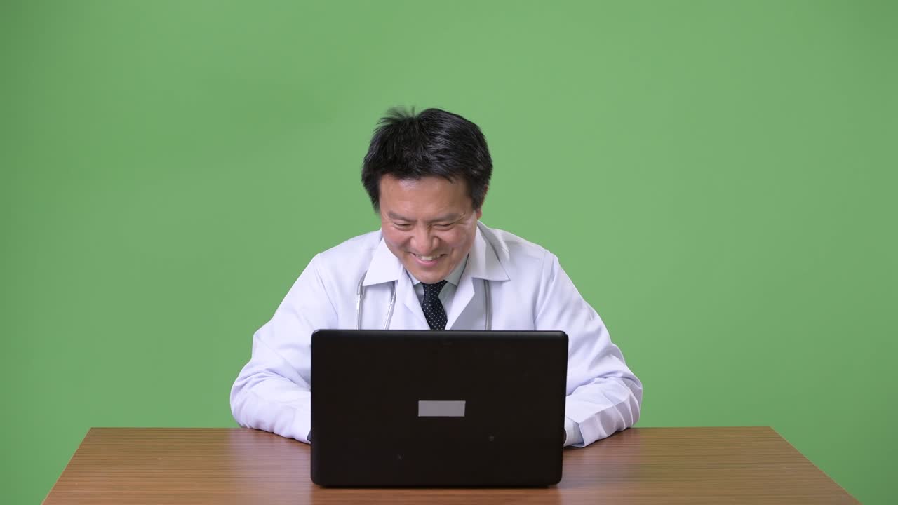 성숙한 일본인 남성, 초록색 배경의 의사