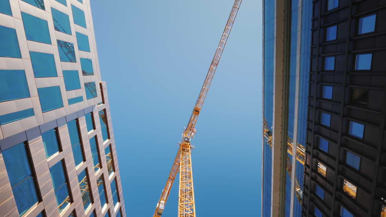A Huge Construction Crane Near Office Buildings With Glass Facades City Building Steadicam Shot