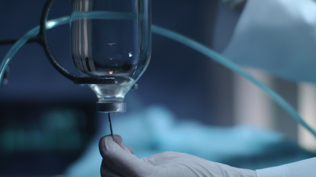 Gloved hand put needle in drop counter. Chemotherapy bottle