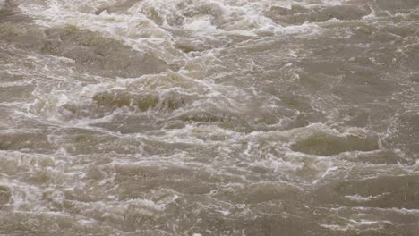 4k murky raging water from a reservoir in thailand with close up of current from torrential rainfall