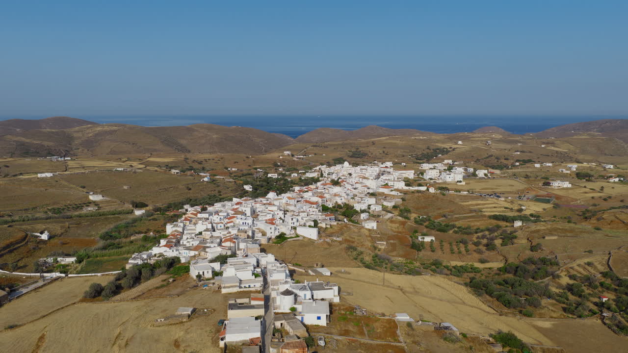 Kythnos Chora village on Kythnos island at sunrise with beach in background, Cyclades, Panoramic view, Drone
