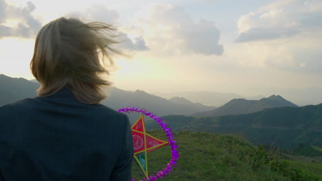 disparo en cámara lenta de un modelo sosteniendo una linterna estelar en la cima de una montaña al atardecer