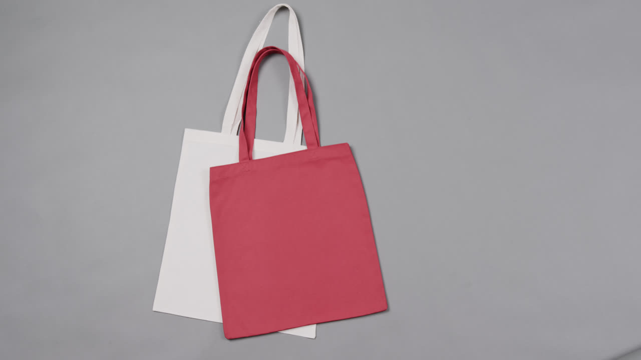 primer plano de bolsas blancas y rojas sobre un fondo gris, con espacio de copia, cámara lenta