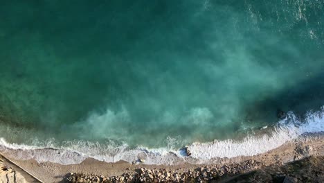 Top-Down-shot-with-dron-of-Baska-beach-dolly-to-right-above-adriatic-sea-in-a-sunny-day