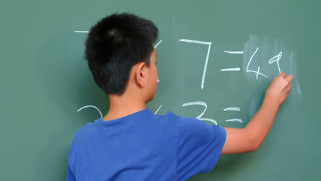 rear view of asian schoolboy solving math problem on chalkboard in classroom at school 4k