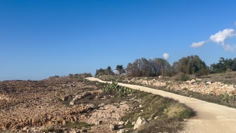 Walking-next-to-beach-in-Paphos,-Cyprus