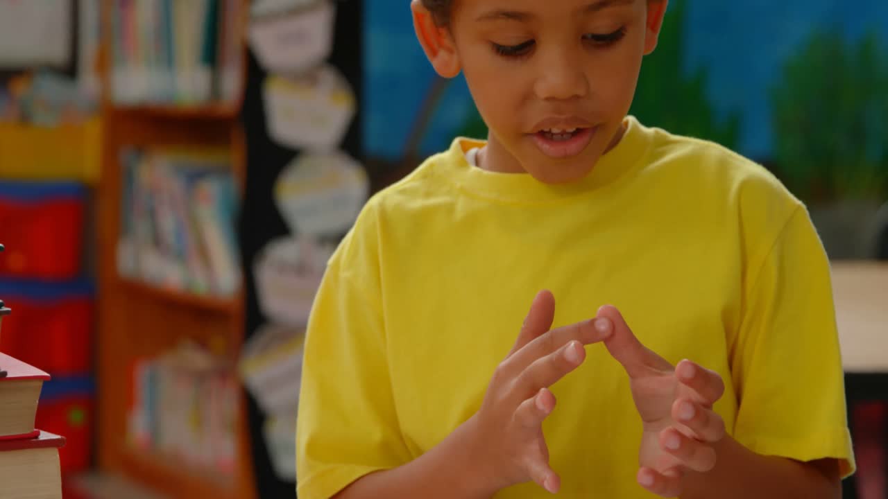 Front view of African American schoolboy counting with his finger at desk in a classroom at school 4