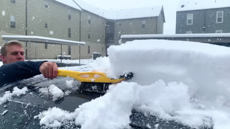 Top-Down-View-of-Man-Taking-Snow-off-of-Car-Surface,-Slow-Motion,-4K