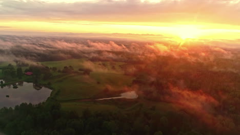 nubes delgadas sobre las verdes colinas, los árboles y el lago al atardecer