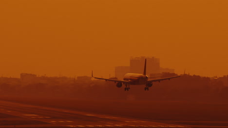 vista frontal de un avión de carga que aterriza en la pista de aterrizaje del aeropuerto con humo blanco de la rueda