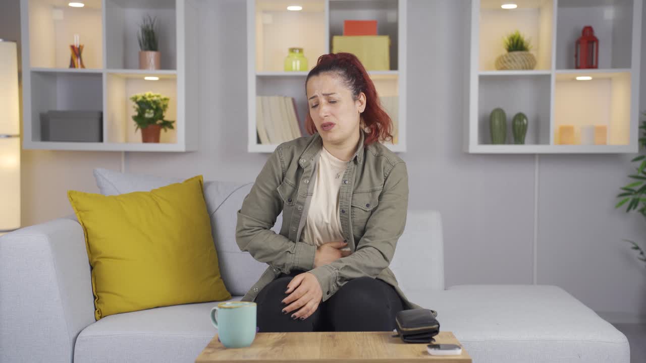 배고픈 여자가 배를 잡고 있다. 돈이 없습니다.