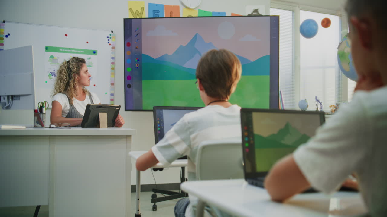 Teacher Using Tablet Computer Educating Young Students Showing Digital Process of Drawing on Digital
