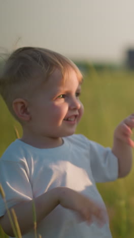 una mujer alegre con un vestido azul abre una pequeña botella espumosa en un campo cubierto de hierba mientras un joven feliz con una camiseta blanca observa con deleite, capturando un momento de emoción compartida y juguetón