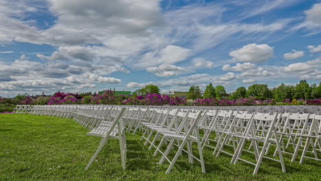 clouds moving over rows of empty wooden white chairs