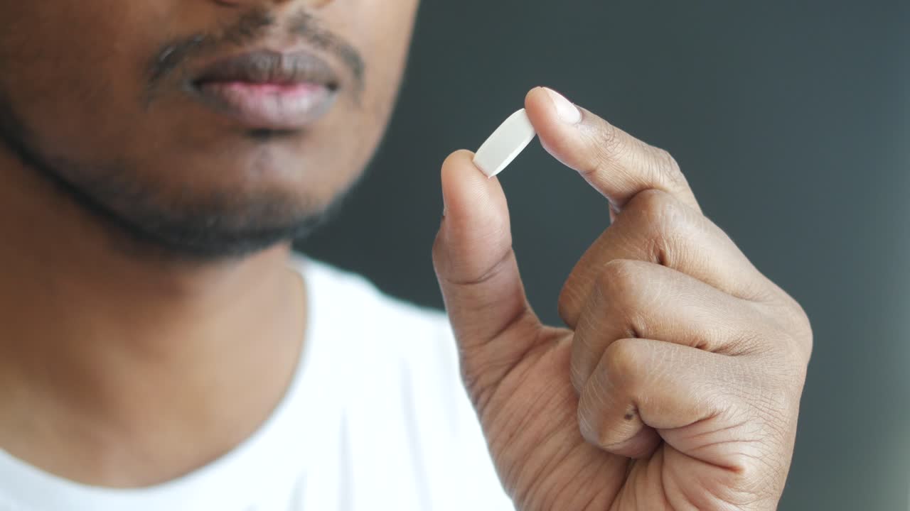 persona que sostiene una píldora