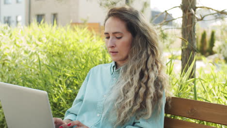 Hermosa-Mujer-Caucásica-Trabajando-En-Una-Laptop-En-El-Parque